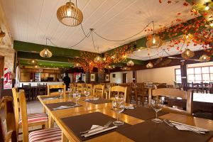 a restaurant with wooden tables and chairs and lights at Hostel Pioneros del Valle in El Chalten