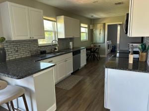 a kitchen with white cabinets and black counter tops at Nancy Haven in Port Saint Lucie