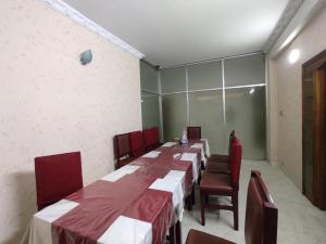 a dining room with a long table and chairs at Suite Palace in Dhaka
