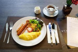 a plate of food with eggs sausage and vegetables and a cup of coffee at Suite Palace in Dhaka