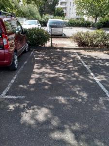 a red car parked in a parking lot at Appart T1bis 31m2 Blagnac proche Tram in Blagnac +2 photos