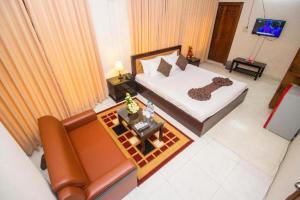 a room with a bed and a couch and a television at Suite Palace in Dhaka +41 photos
