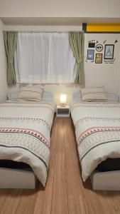 two beds sitting next to each other in a bedroom at Takamatsu-house201 in Shimminatomachi