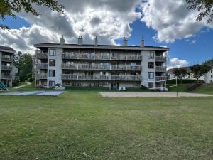 a large building with a playground in front of it at Au p'tit cocon sur le lac in Magog-Orford