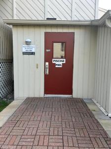 梅戈格Au p'tit cocon sur le lac的大楼的红色门,上面有标志 更多29张照片