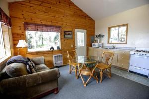 un salon avec un canapé et une table en verre dans l'établissement Spacious Waterfront Cabin Rental on the Shores of Cook Inlet, Alaska, à Kasilof