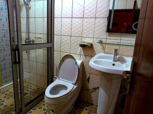 a bathroom with a toilet and a sink at Applegate Hotel in Yaoundé