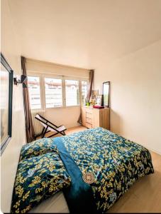 a bedroom with a bed with a blue comforter at ANGLET, Chambre privée, QUINTAOU in Anglet