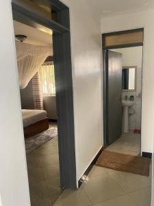 a room with a mirror and a bathroom with a sink at Alexandria Suites rooms in Kampala