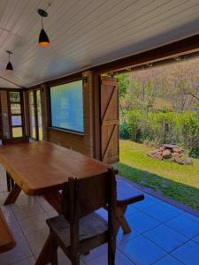 ein Holztisch und eine Bank auf einer Terrasse in der Unterkunft Casa na serra da Mantiqueira in São José dos Campos