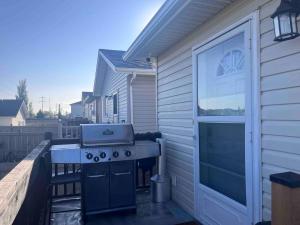 ein Grill auf einer Terrasse neben einem Haus in der Unterkunft Casa Tarriela by Noel and Liza-Bungalow Upstairs in Edmonton