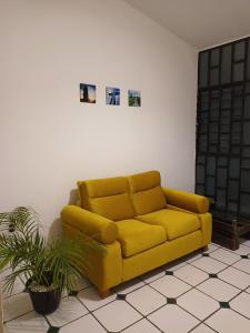 a yellow couch sitting in a living room at Casa Xico 424- Centro, Xicotepec, Puenlo Magico in Xicotepec de Juárez