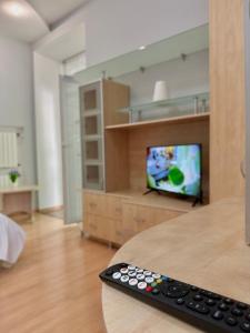 a remote control sitting on a table in front of a television at 1 room right near the Kreschatyk in Kyiv