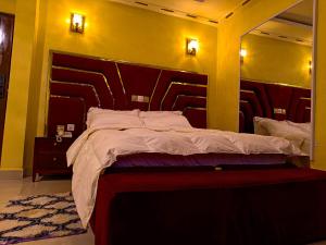 a bedroom with a large bed and a large mirror at Applegate Hotel in Yaoundé