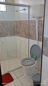 een badkamer met een toilet en een douche bij Residencial Roma AP01 in Capão da Canoa