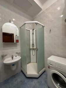 a bathroom with a shower and a sink and a washing machine at 1 room right near the Kreschatyk in Kyiv +15 photos