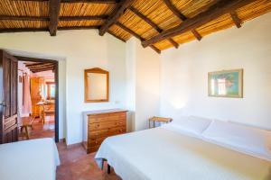 ein Schlafzimmer mit einem weißen Bett und einer Holzdecke in der Unterkunft Appartamenti Tiffany in San Teodoro