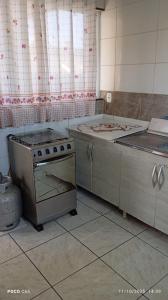 een keuken met een fornuis en een wastafel. bij Residencial Roma AP01 in Capão da Canoa