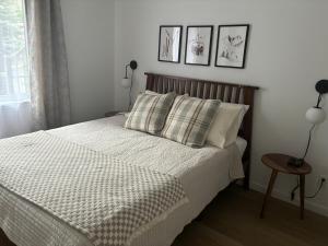 ein Schlafzimmer mit einem Bett und zwei Bildern an der Wand in der Unterkunft Ski in out condo sur la montagne in Bromont