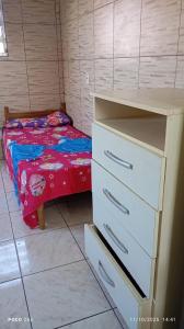 een kleine slaapkamer met een bed en een dressoir bij Residencial Roma AP01 in Capão da Canoa