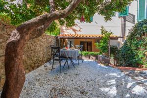 einen Tisch und Stühle unter einem Baum im Hof in der Unterkunft Elegante Appartamento a 2 passi dal centro storico in Florenz