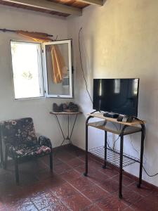 a room with a tv and a chair and a table at La Caprichosa in Reta