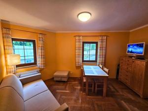 a living room with a couch and a table at Rodinný apartmán Pec pod Sněžkou 3 - 1x parking available in Pec pod Snezkou