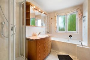a bathroom with a sink and a tub and a shower at Ferienwohnung Baier in Überlingen +23 photos