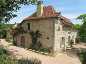 an old stone building with a red roof at Mas del Lum in Boussac