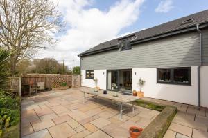 a patio with a wooden table in front of a house at Kim's Place in Hingham