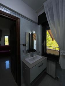 ein Badezimmer mit Waschbecken, Spiegel und Fenster in der Unterkunft B&B Villa Diamante in Scafati + 46 Fotos