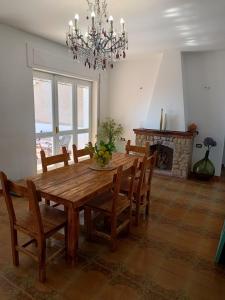 a dining room with a table and chairs and a chandelier at Margareth suite and terrace in San Lucido
