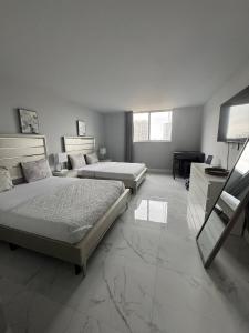 a bedroom with two beds and a desk and a television at Modern Apartments Ocean Reserve Sunny Isles Beach in Sunny Isles Beach +57 photos