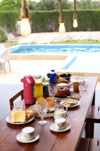 a wooden table with food and drinks on top of it at Casa da GabiLu in Itapipoca