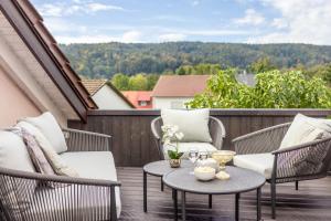 eine Terrasse mit zwei Stühlen und einem Tisch auf einem Balkon in der Unterkunft Jolie's Cottage in Iznang
