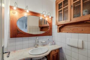 ein Badezimmer mit Waschbecken und Spiegel in der Unterkunft Jolie's Cottage in Iznang + 10 Fotos