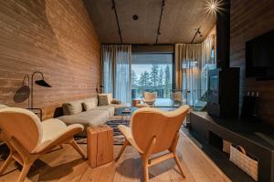 a living room with a couch and chairs and a tv at Villa Lumi 2 Levi in Kittilä
