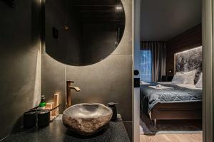 a bathroom with a sink and a bedroom with a bed at Villa Lumi 2 Levi in Kittilä