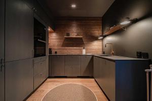 a large kitchen with a sink and a rug at Villa Lumi 2 Levi in Kittilä +11 photos