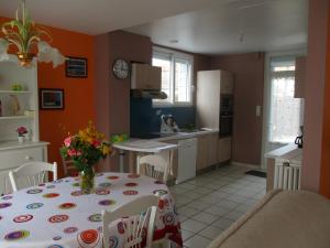 une cuisine avec une table avec un vase de fleurs dessus dans l'établissement aldaro, à La Celle-sous-Gouzon