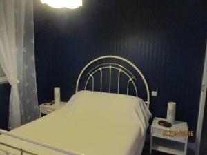 Ce lit se trouve dans une chambre dotée d'un mur bleu. dans l'établissement aldaro, à La Celle-sous-Gouzon