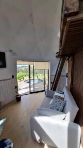 サント・ドミンゴにあるDomo en la Reserva El Yali, con jacuzzi privadoの白いソファと大きな窓のあるリビングルーム