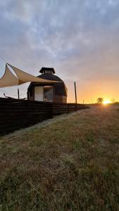 サント・ドミンゴにあるDomo en la Reserva El Yali, con jacuzzi privadoの夕暮れの野原にテントが張られた建物