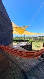 サント・ドミンゴにあるDomo en la Reserva El Yali, con jacuzzi privadoのハンモックが建物の横に結ばれている +6枚の写真