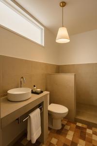 Un baño con lavabo, inodoro y ventana. en Ims'Chill Hotel, en Imsouane