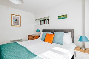 a bedroom with a bed with blue and orange pillows at Lower Marsh Farm B&B in Saltash