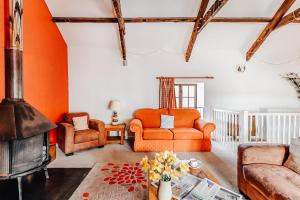 a living room with orange furniture and a fireplace at Lower Marsh Farm B&B in Saltash