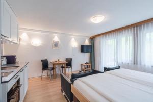 Una habitación de hotel con una cama, una mesa y sillas. en Bolero Appartements, en Zermatt