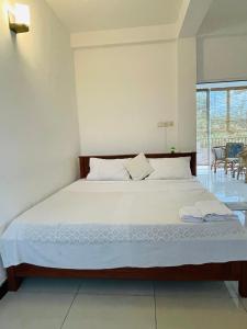 ウェリガマにあるBe Happyの白いシーツが敷かれた大きなベッドのある寝室