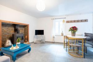 a living room with a couch and a table and a fireplace at Ce Petit Penty in Douarnenez